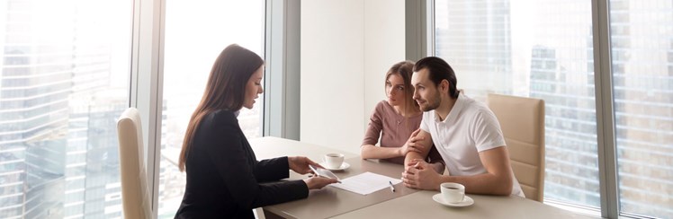 Couple reviewing contract with Real Estate Agent