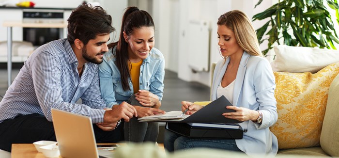 Couple reviewing mortgage documents with realtor