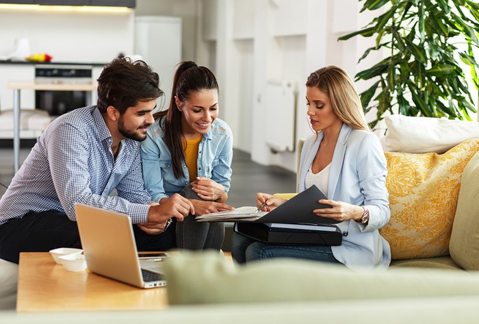 Couple reviewing a contract with woman realtor