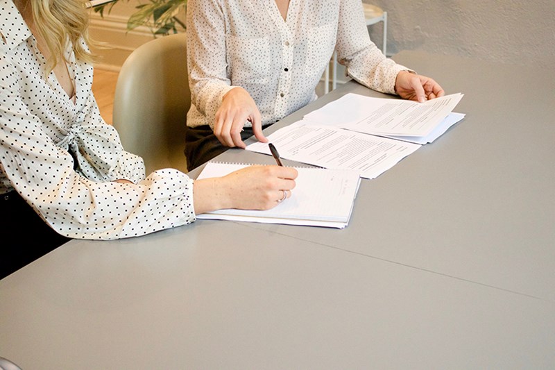 Two women signing a contract