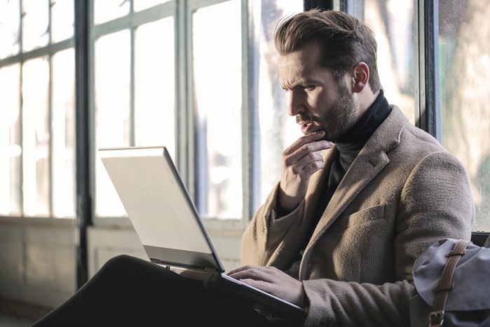 Perplexed looking man staring at laptop